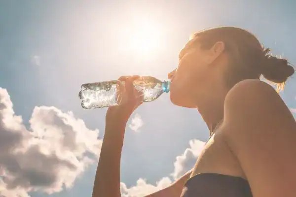 Hydration: The Secret Ingredient for a Toned Stomach and Enhanced Fitness 3 Image of woman drinking water to hydrate Thurrock Park after run.