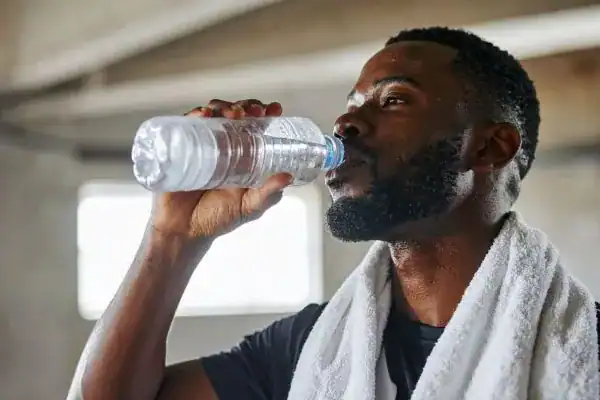 Hydration: The Secret Ingredient for a Toned Stomach and Enhanced Fitness 1 Image of man drinking water to improve hydration Thurrock Park after work out.